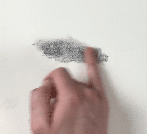 using a finger to create soft edges in a charcoal drawing