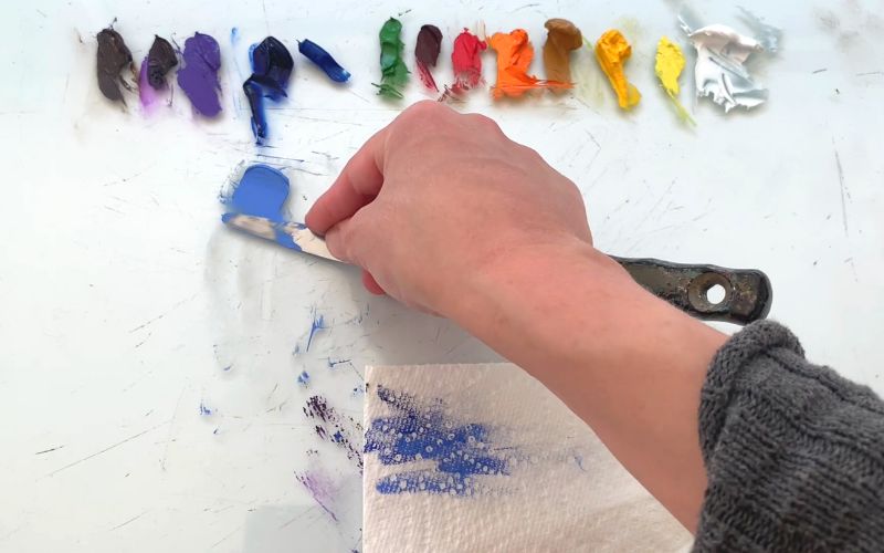 artist shows how to make blue lighter while mixing on their palette